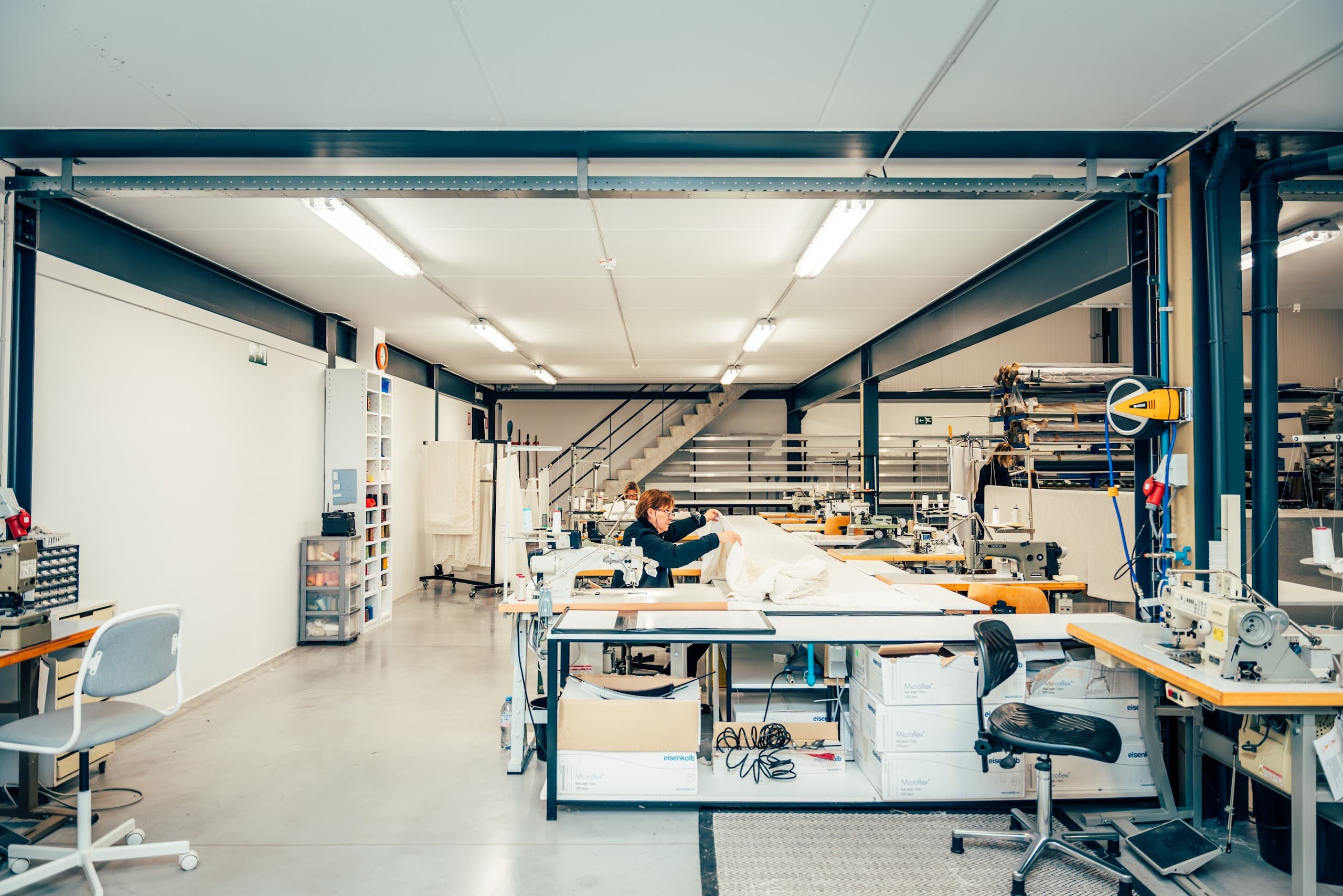 Het atelier van Lian met ruime werktafels en stofrollen.