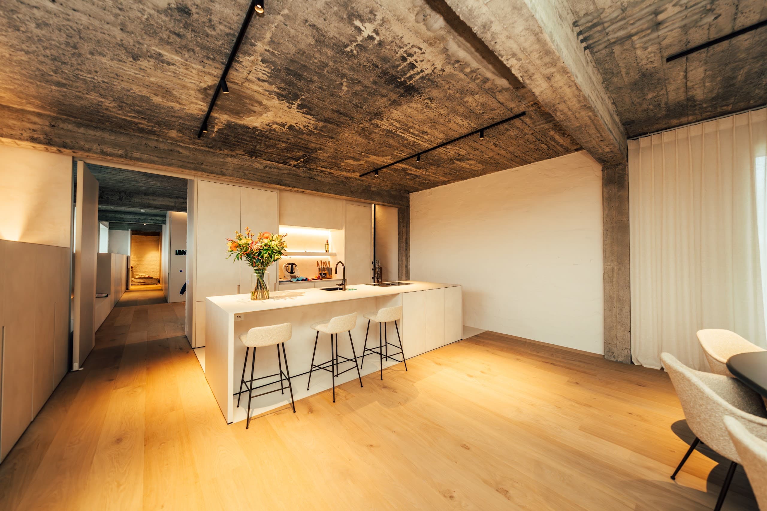 Woonkamer met loungebank en gordijnen die het daglicht temperen