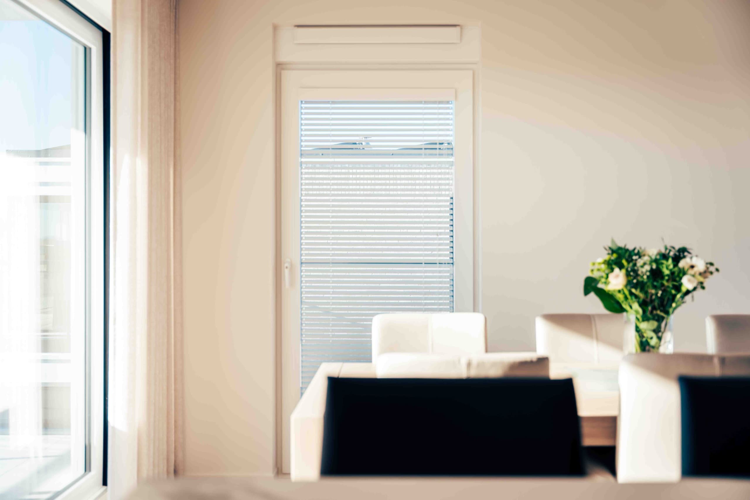 Eethoek met witte horizontale lamellen voor de terrasdeur