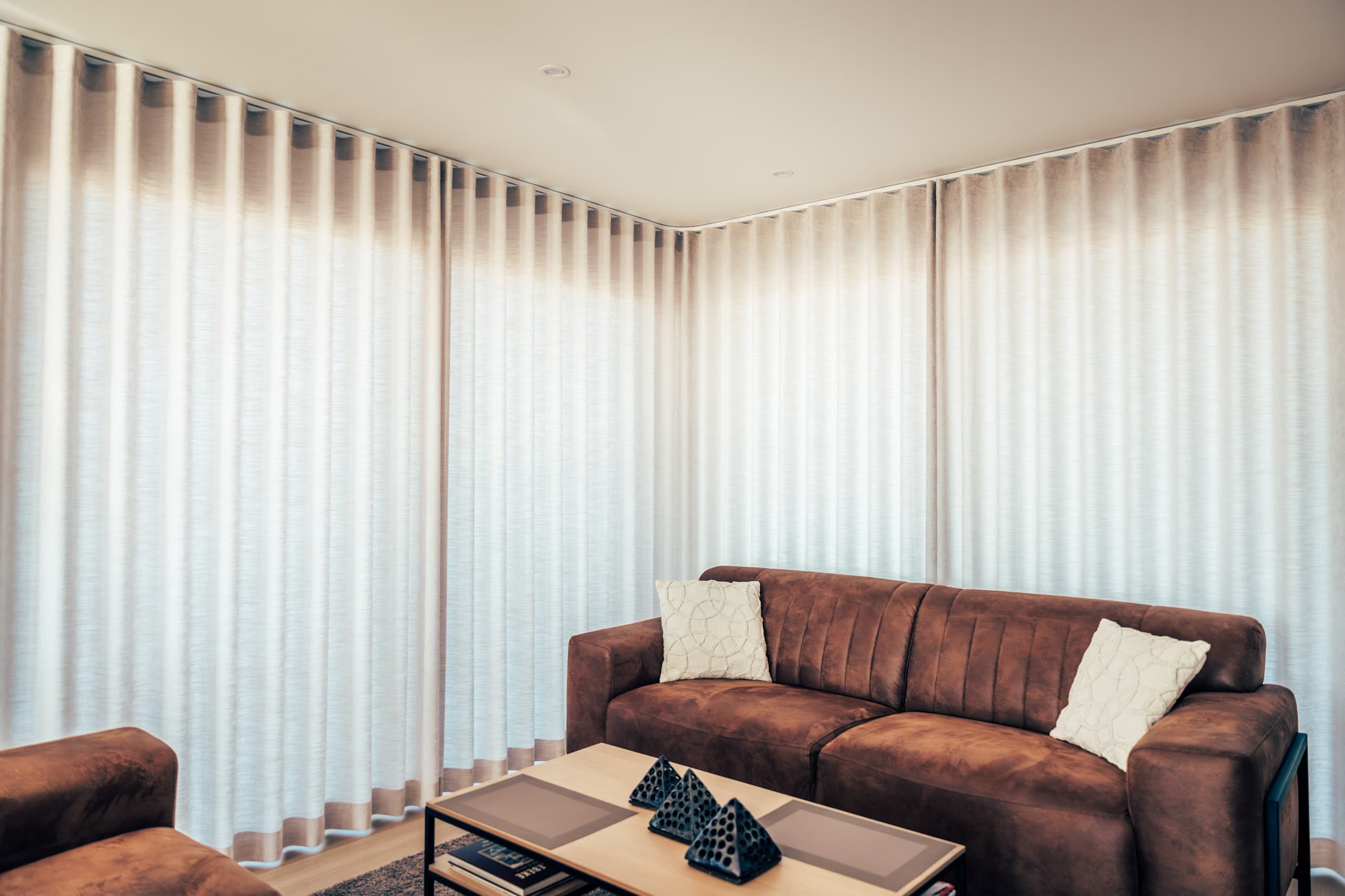 Interieur van een moderne woning met soepel vallende gordijnen in de leefhoek