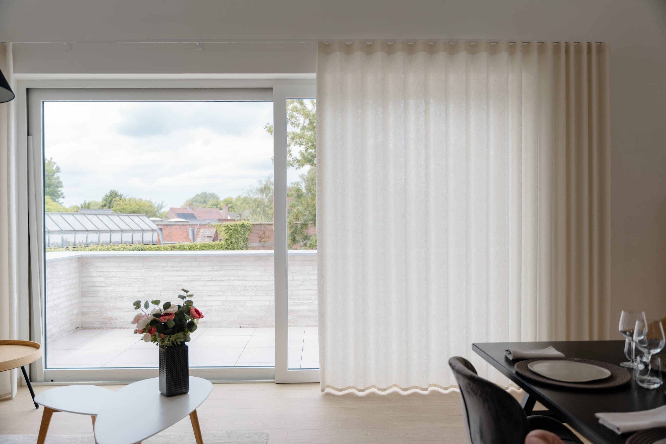 Eethoek in het modelappartement met transparante gordijnen