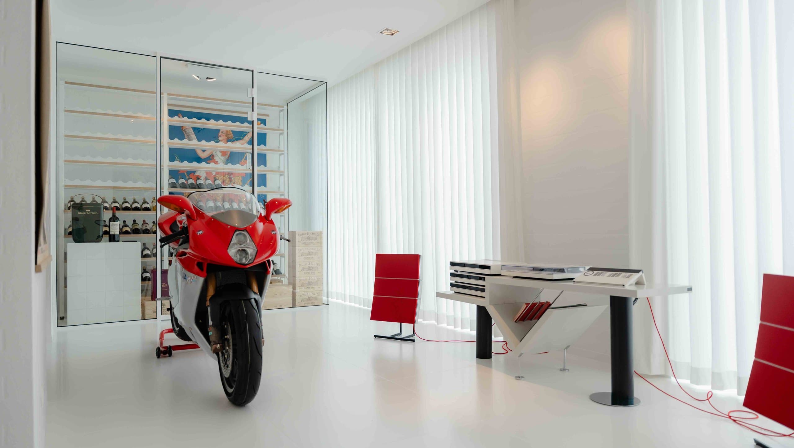 Collectieruimte met motorfiets, bureau en verticale lamellen langs de volledige raamwand
