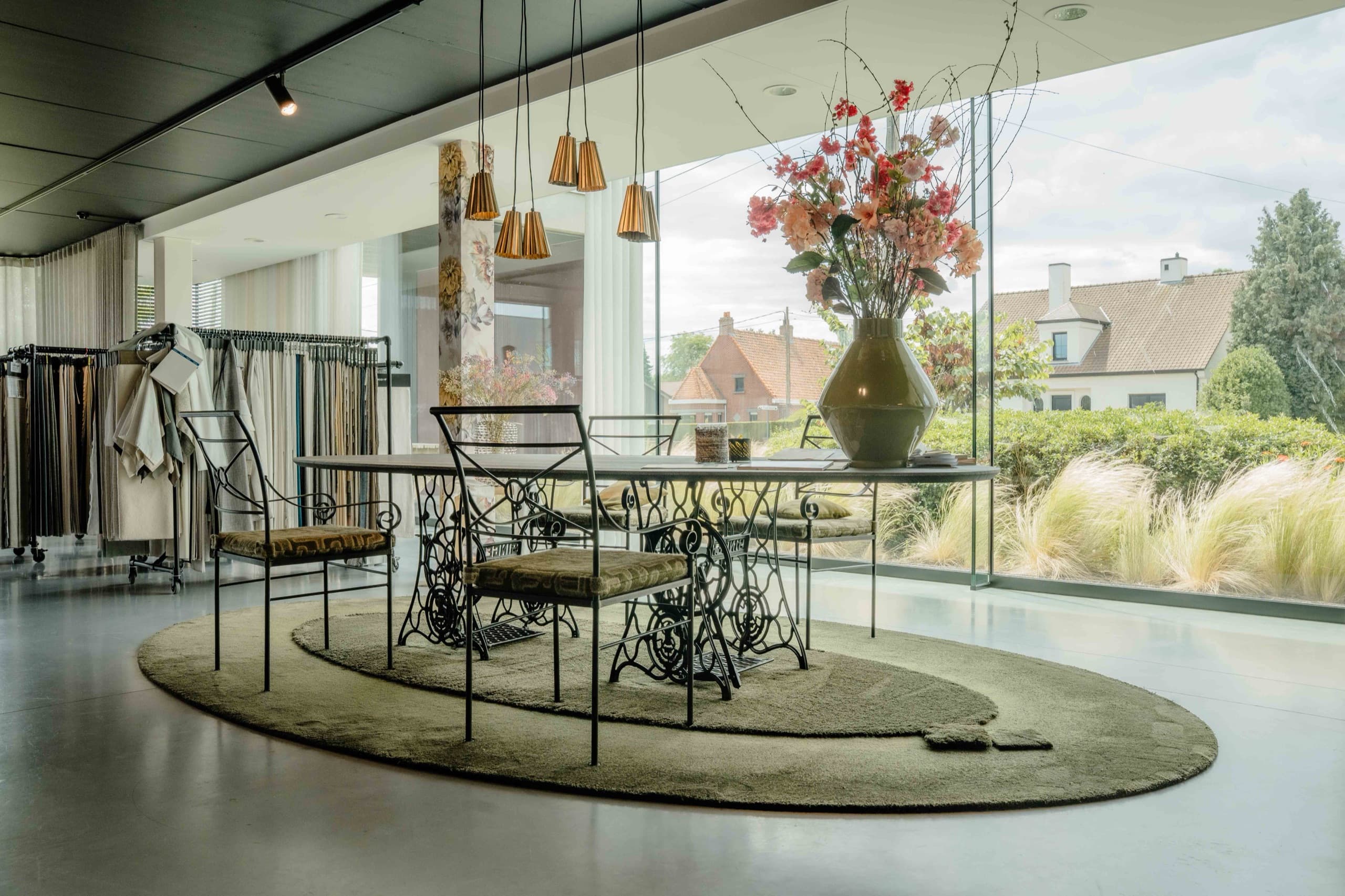 Ovale tafel op een rond hoogpolig tapijt bij de raampartij